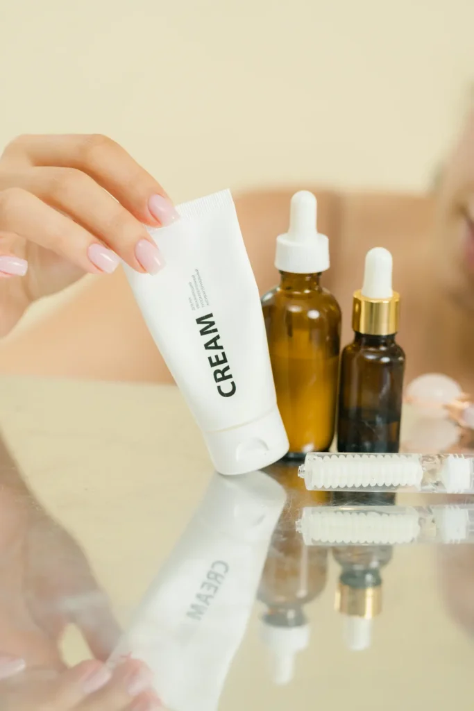 Różne rodzaje podkładów kosmetycznych ułożone na lustrze z naturalnym tłem