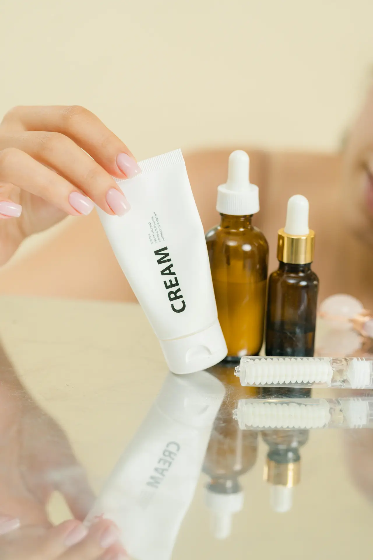 Różne rodzaje podkładów kosmetycznych ułożone na lustrze z naturalnym tłem